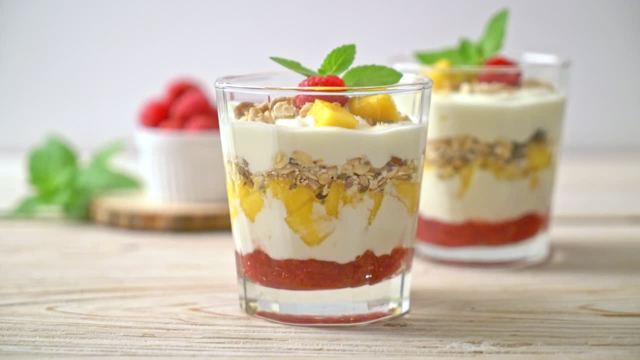 mango fresco casero y frambuesa fresca con yogur y granola - estilo de comida saludable