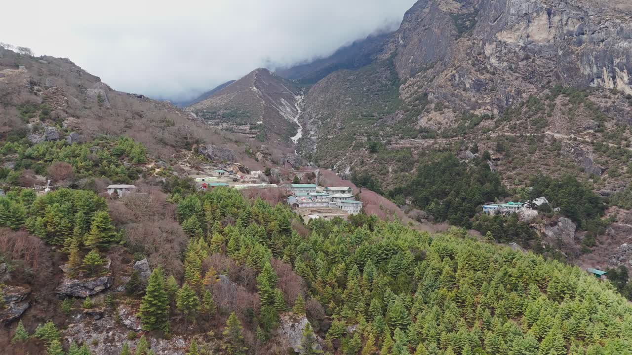 A peaceful mountain village rests along the Everest Base Camp trail, surrounded by lush green hills and stunning Himalayan views.