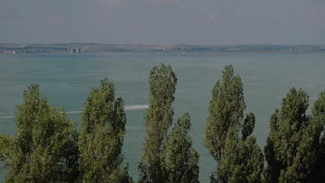 Toma-Distante-De-Un-Piloto-De-Jet-De-Esquí-Acuático-Que-Va-A-Alta-Velocidad-En-Un-Lago-Azul-En-Un-Día-Soleado-Y-Cálido-De-Verano