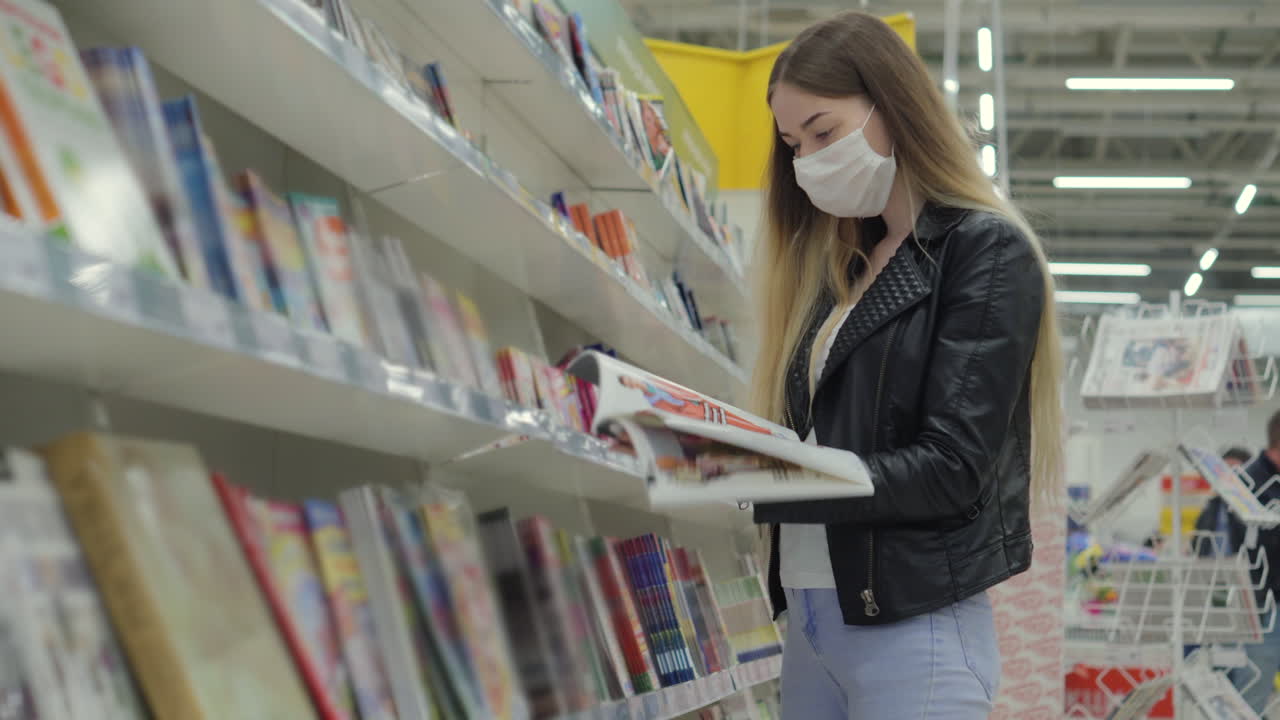 Woman Browsing Books in a Store Wearing a Mask