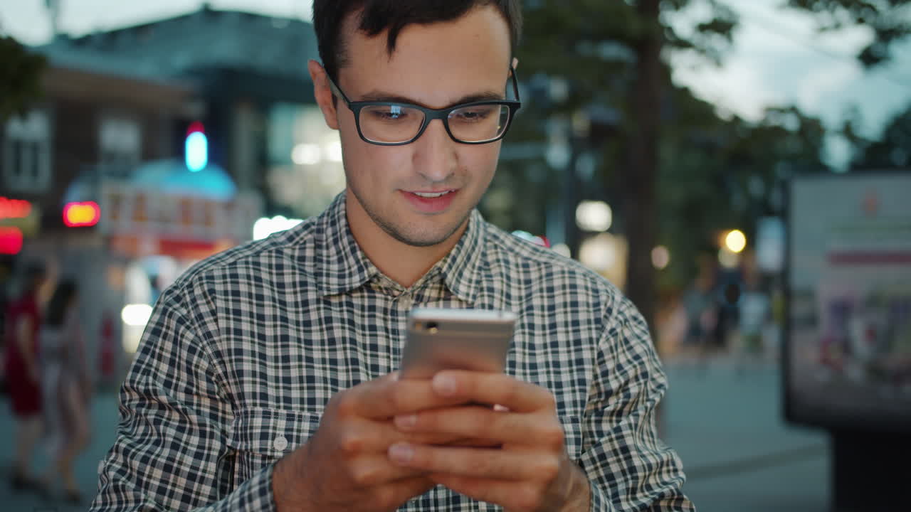 Man using smartphone in city at night