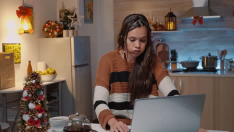 Mujer-Caucásica-Sentada-En-La-Mesa-De-La-Cocina-Con-Una-Computadora-Portátil