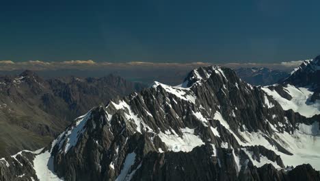 SLOWMO---Snow-capped-rocky-mountains-in-Aoraki-Mountain-Cook-National-Park,-Southern-Alps,-New-Zealand-from-airplane-scenic-flight-with-glacier-Lake-Pukaki-in-background