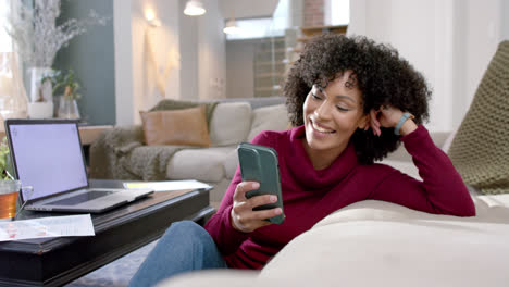 Mujer-Birracial-Feliz-Con-Perro-Usando-Laptop-Y-Teléfono-Inteligente-En-Casa,-Cámara-Lenta