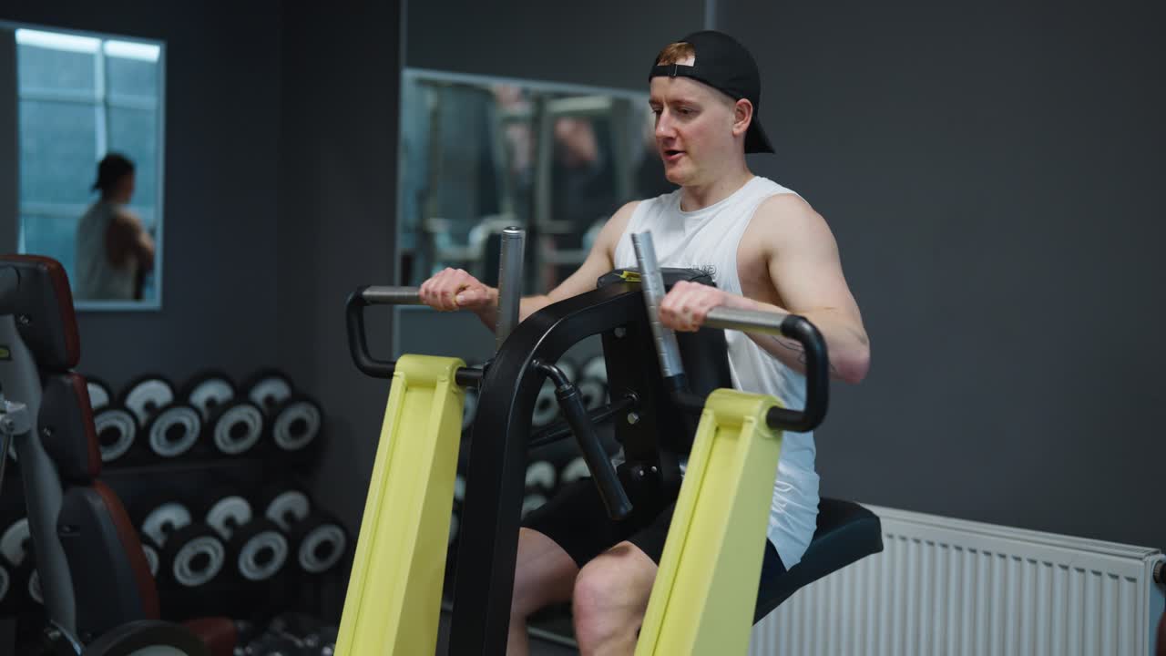 Caucasian male athlete train back muscle group with leverage low row machine