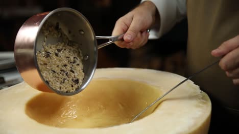 chef preparing risotto in a large parmesan cheese
