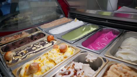 a couples hands choosing ice cream in an italian gelato shop