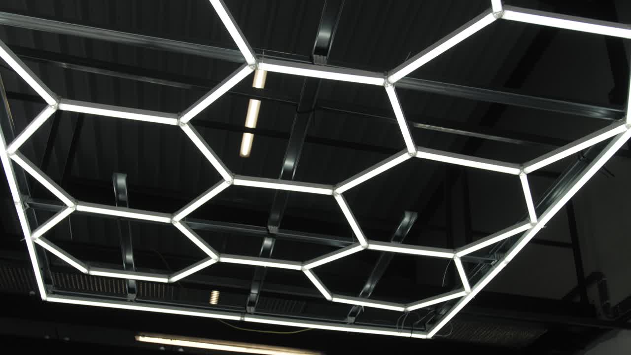 Dynamic view of a geometric LED lighting installation, common in automotive workshops