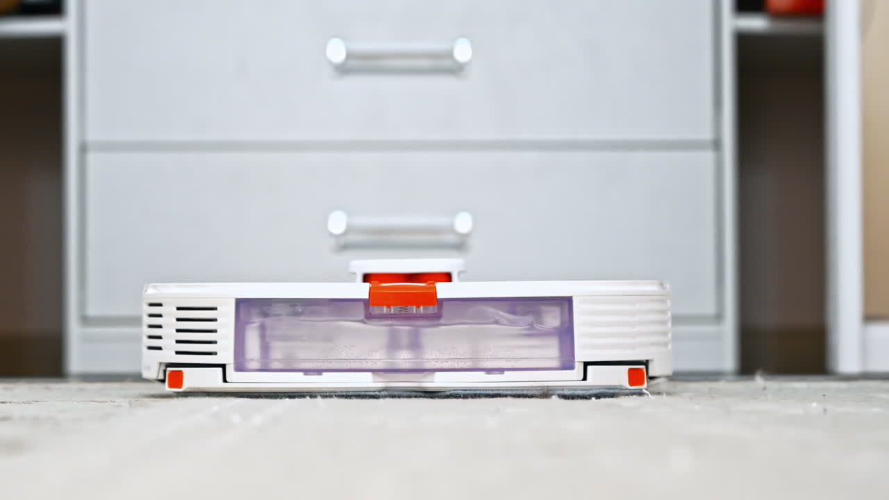 Working robotic vacuum cleaner at home, moving on a carpet