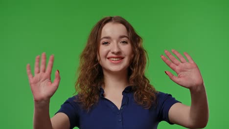 woman waving hands in front of green screen
