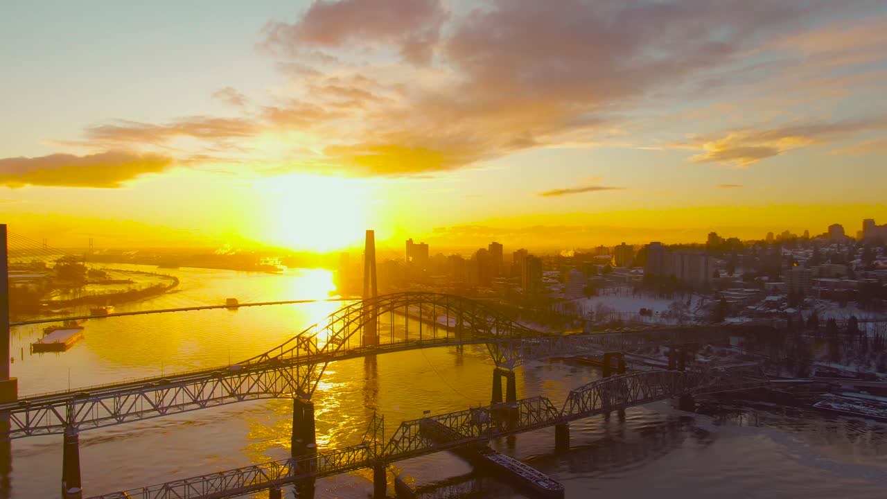 Aerial Panoramic View of the Modern City, Bridge and Fraser River during a colorful Sunset. Taken in New Westminster, Vancouver, British Columbia, Canada.