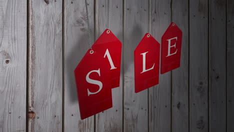 red sale tags hanging against wood