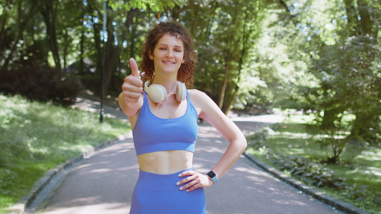 atleta en forma sonriente corredora feliz por el logro de la maratón mostrando el pulgar hacia arriba como un gesto