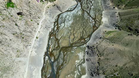 top down birds eye view drone shot lake water running through mountain valley