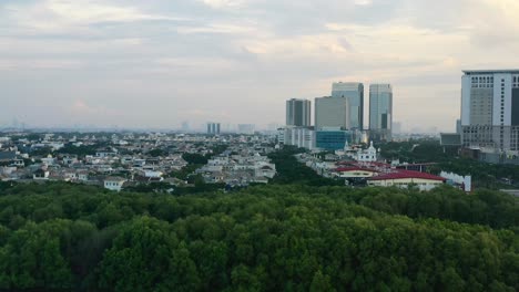 aerial pan left of metropolitan area of pik in jakarta indonesia at sunset with modern eco buildings