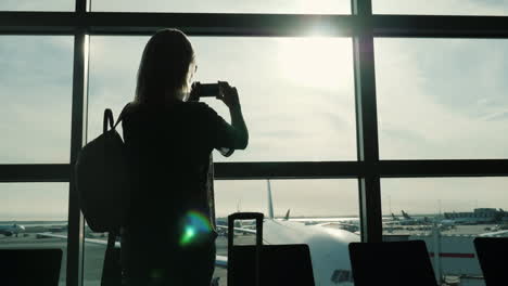 turista tomando fotos desde la terminal del aeropuerto