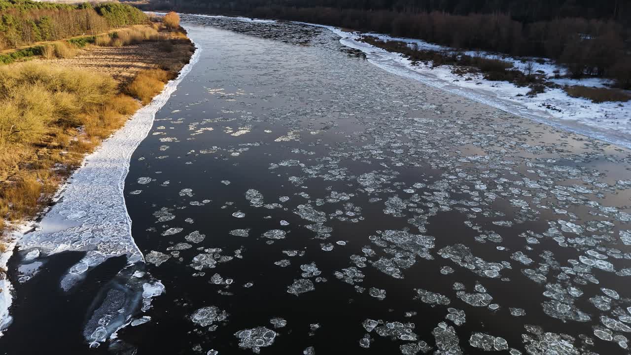 Calm river with flowing ice in Lithuania, aerial view