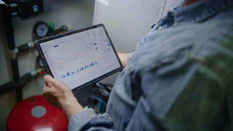 Worker Monitoring Real-Time Stocks, Exchange Market Charts Using Smartphone. Man Making Cryptocurrency Investments During Working Day in Warehouse, Combining Job with Online Trading. Close Up Shot.