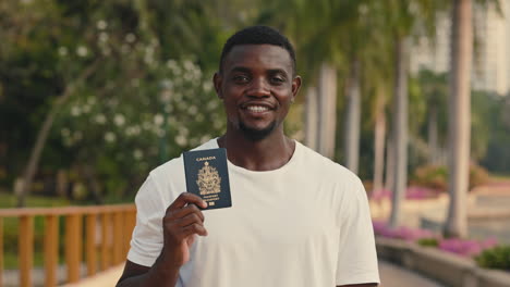 man holding a canadian passport in a park