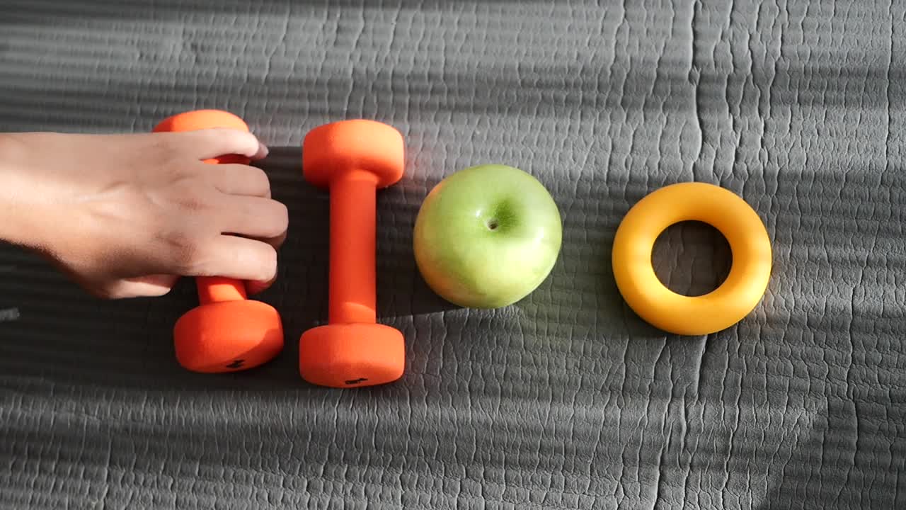 Dumbbells, apple, and hand exerciser