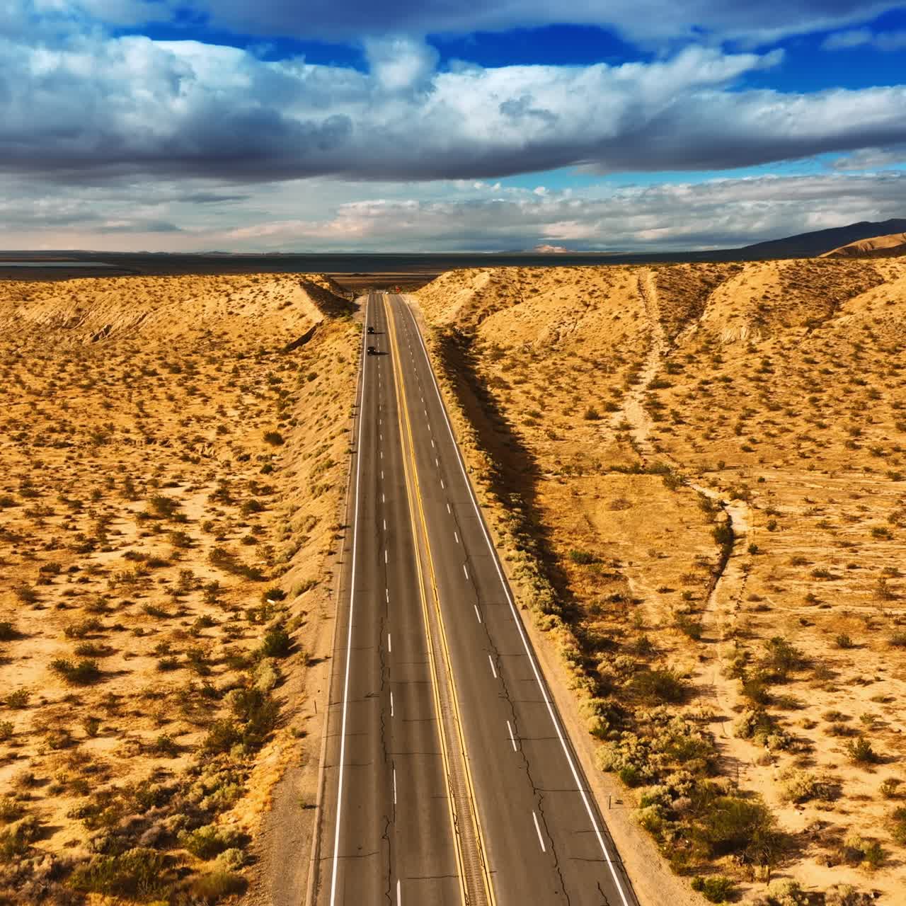Footage above the highways in Nevada desert, USA. Gorgeous cloudscape in the sky at backdrop. Top view