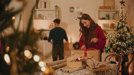 mujer con una caja de regalos de pie frente a su novio