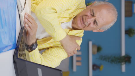 Vertical-video-of-Home-office-worker-old-man-feels-physical-good.