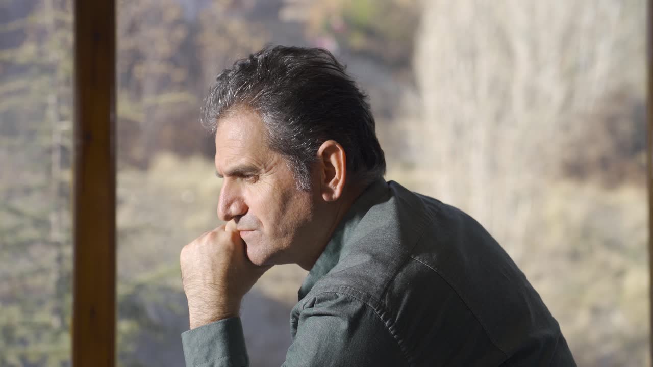 Vecchio pensieroso e triste che guarda fuori dalla finestra, infelice e abbattuto