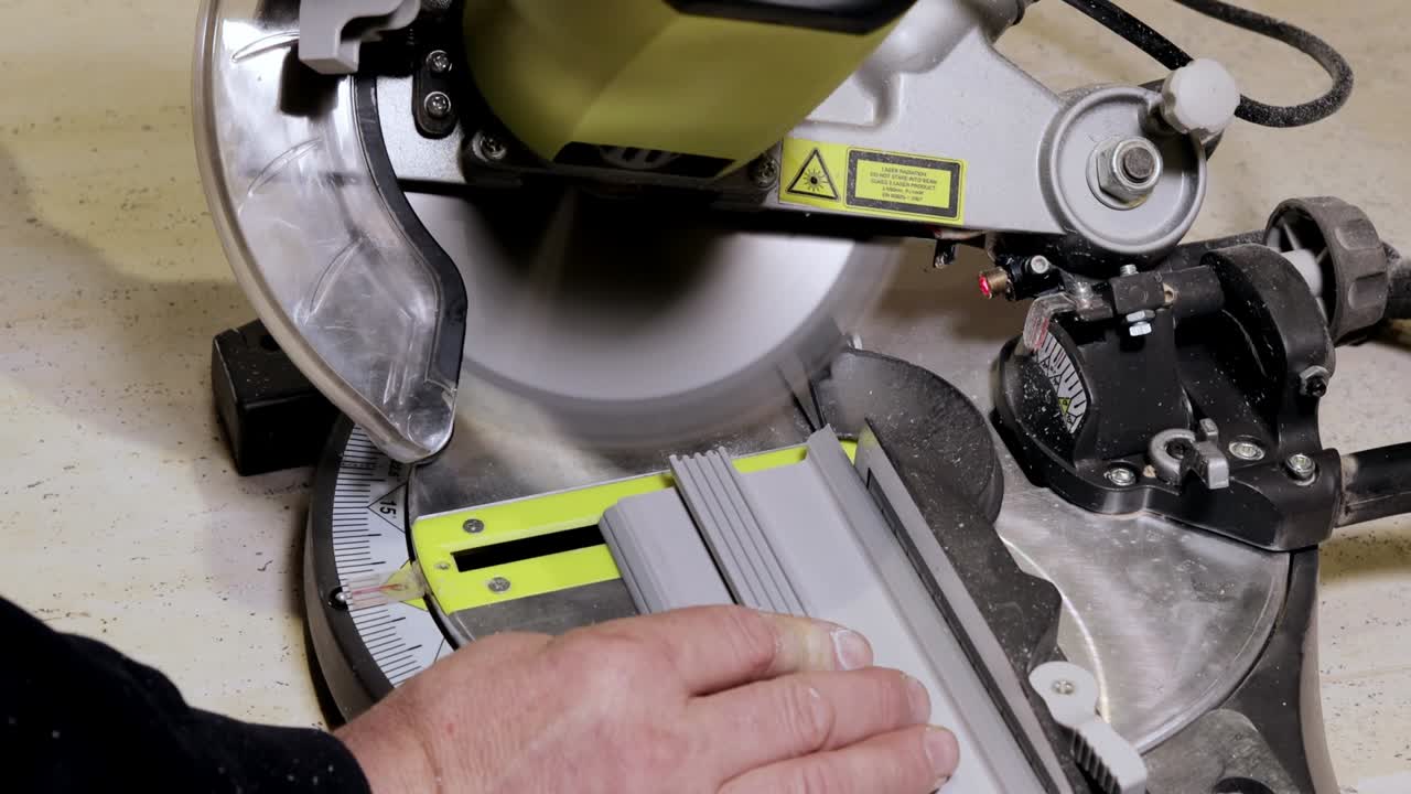 trabajador cortando la base en la sierra circular antes de la instalación.