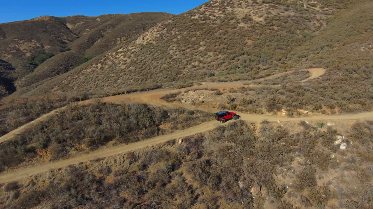 asombrosa vista aérea de un jeep en un sendero todoterreno en un panorama de matorrales desérticos