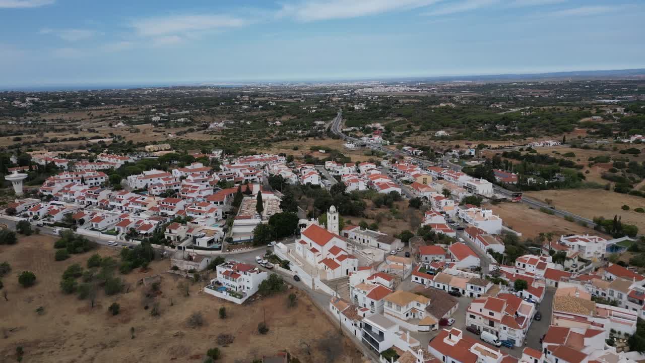 Ampia ripresa con drone sopra la splendida città di Porches, in Algarve, Portogallo, con il drone che vola in avanti.