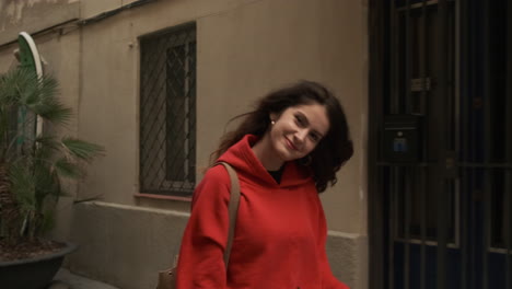 joven sonriendo a la cámara mientras camina por la calle