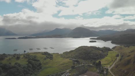 Toma-Aérea-De-Drones-Del-Hermoso-Paisaje-Escocés-En-Las-Tierras-Altas-Del-Norte-Con-La-Bahía-Del-Lago-Y-Las-Montañas-Verdes-En-El-Día-Soleado-Del-Reino-Unido