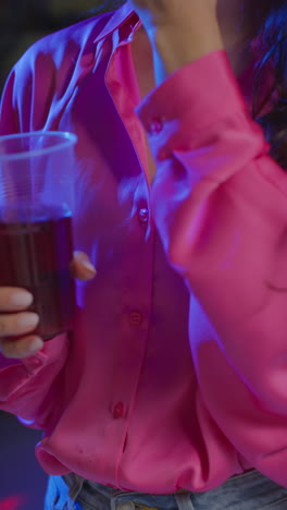video vertical en primer plano de una mujer bebiendo alcohol en una fiesta en casa