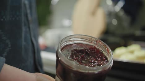 abriendo un frasco de mermelada de frambuesa