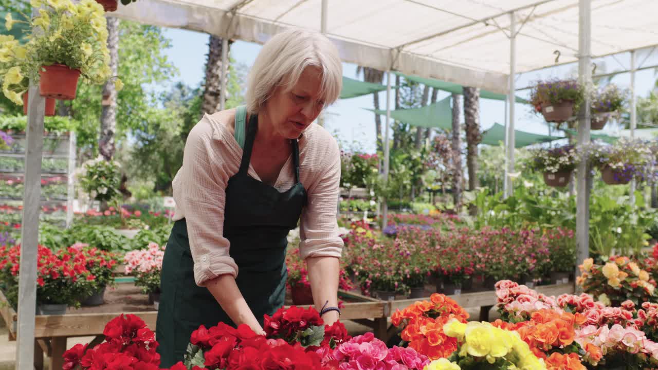 Kvinne som ser på blomster i et hagesenter