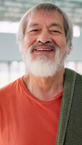 retrato de un anciano sonriente con barba blanca y cabello gris, con una camisa roja y una toalla sobre el hombro. parece estar en buena forma y es probable que esté en el gimnasio o participando en un entrenamiento.