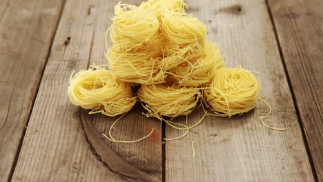 stack of raw tagliati pasta on wooden background