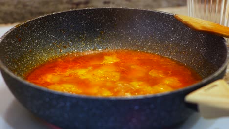 Close-up-on-big-pot-with-wooden-spoon-on-it-and-boiling-food