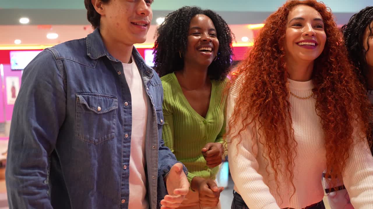 Gruppo di amici che si divertono giocando a bowling
