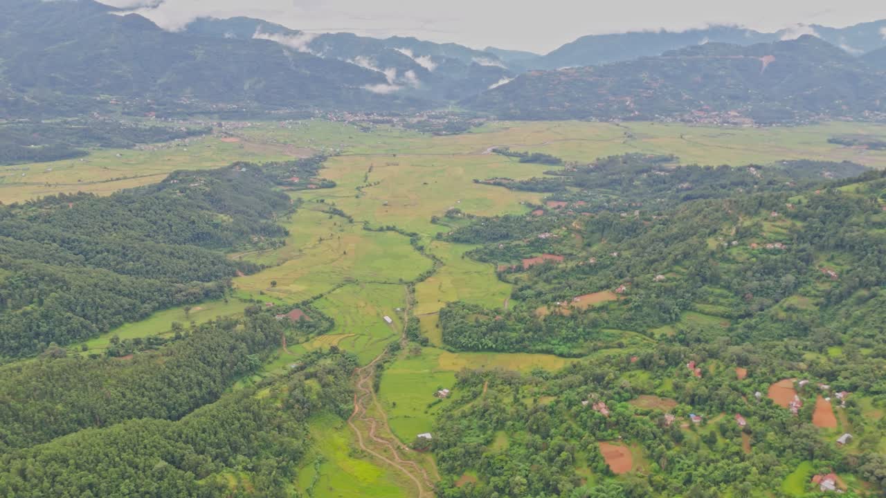 Aerial view of lush green paddy fields in Tansen Palpa, Nepal, surrounded by beautiful mountains and rural landscapes, showcasing the region’s rich agriculture and natural beauty