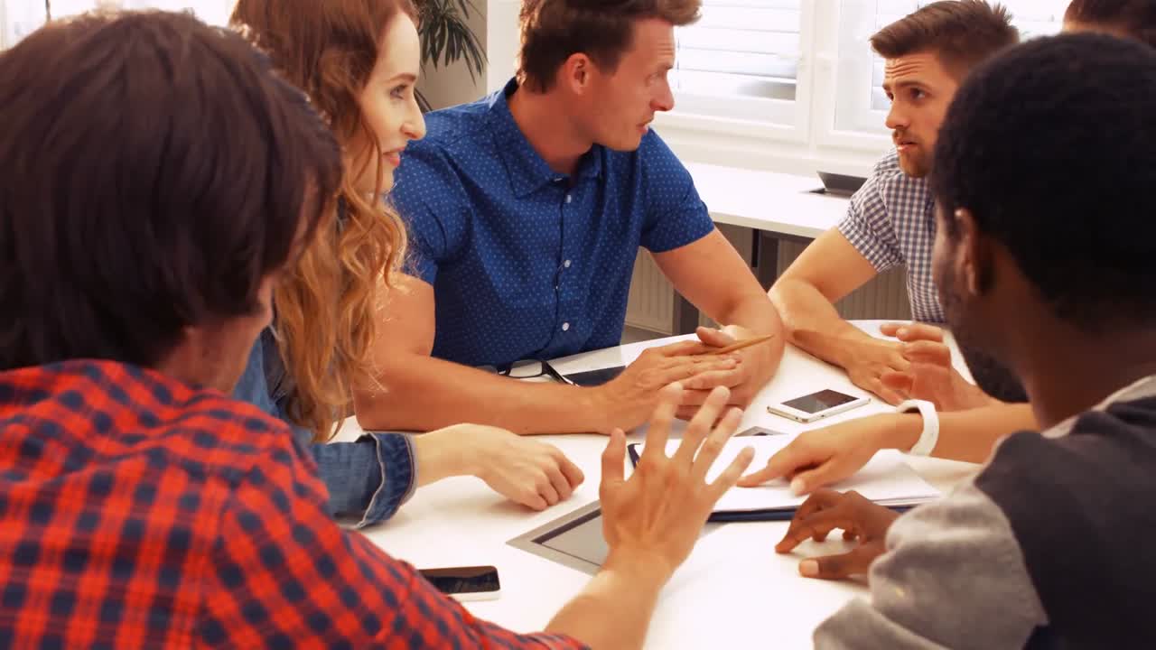 Male and female business executives interacting with each other in a meeting