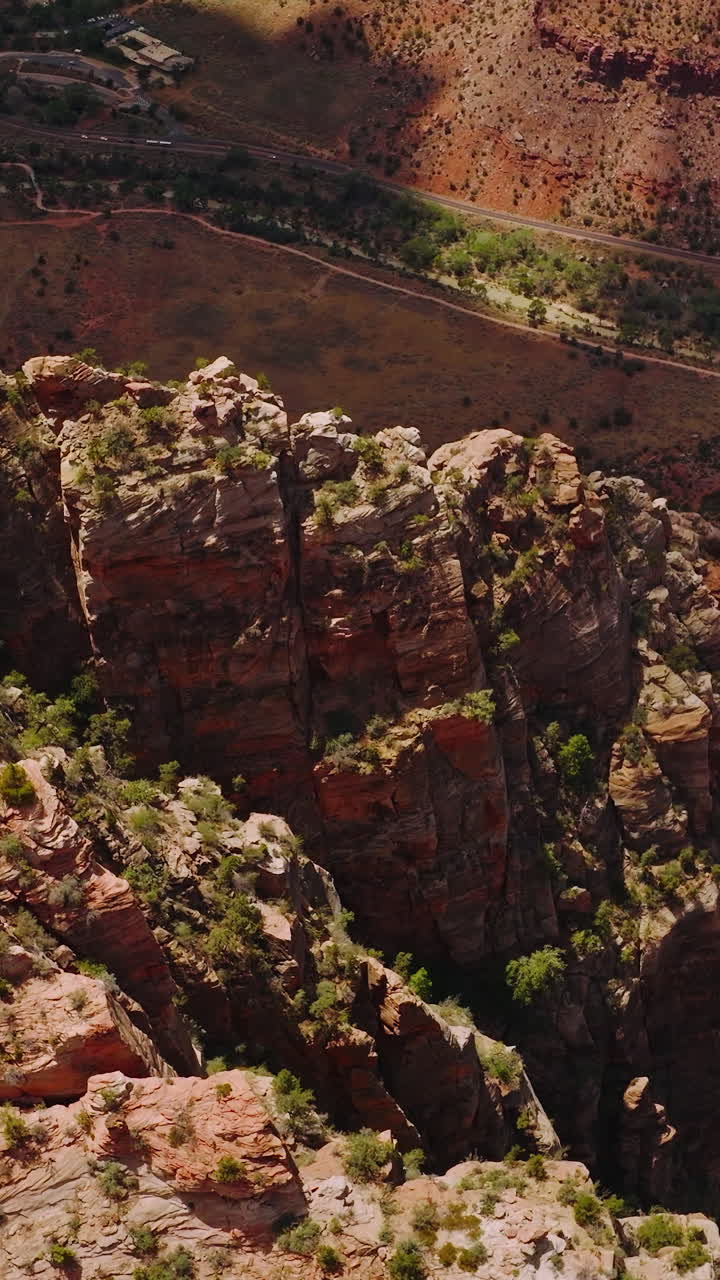 Looking at the tops of amazing canyons with little greenery. High sharp rocks towering over the desert in Utah, USA. Vertical video