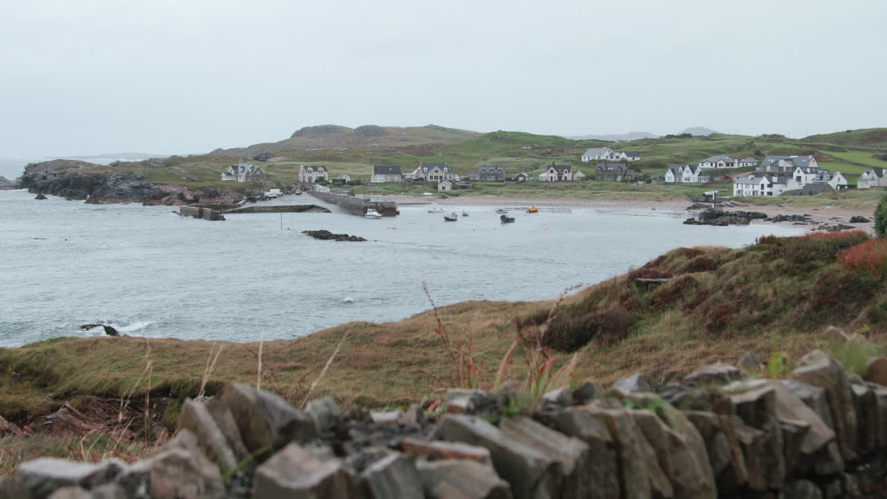 Nestled along the coast of County Donegal, this quaint village showcases boats anchored in a serene bay, framed by rolling green hills and stunning scenery.