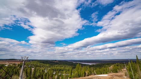 beautiful scenic spring summer landscape in the mountains, forest and river around. ski lift moving with hardly any tourists during lockdown. cable cars. view from the top of the hill. loop