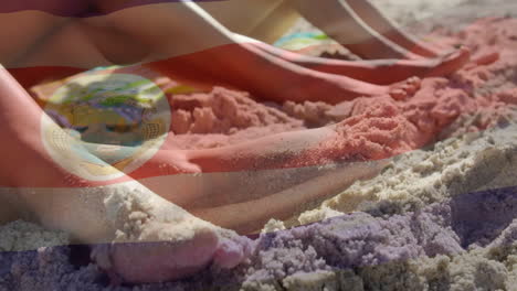 animation of costa rica flag overlaying people relaxing on sandy beach