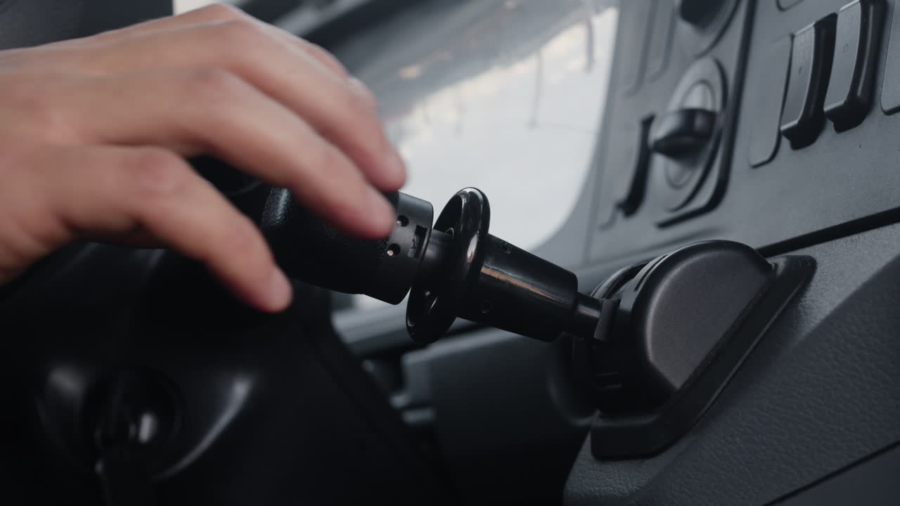 Hand turning ignition key in vehicle