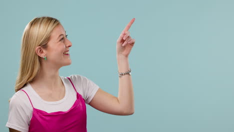 hand pointing, smile and face of woman in studio