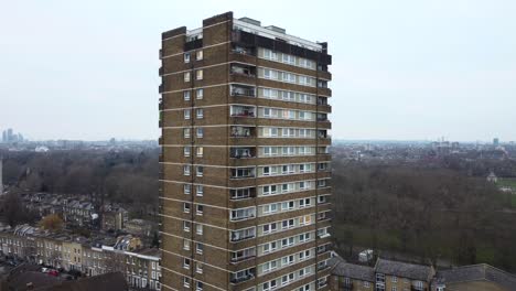 drone shot flying towards old brutalist apartment tower in london