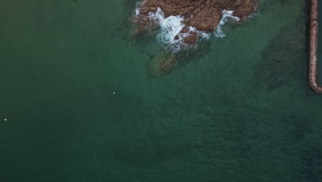 Aerial-top-down-forward-over-rocky-coast-of-Saint-Malo-in-Brittany,-France